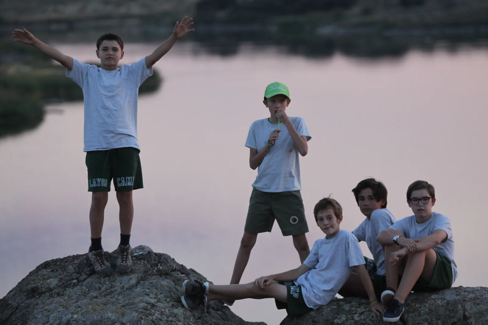 Grupo de campistas sobre las rocas junto al agua, al atardecer, en Toledo
